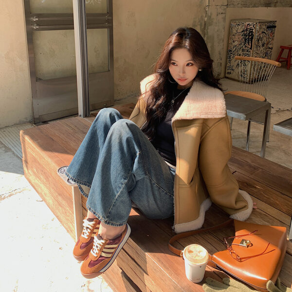 Woman sitting on bench with coffee.