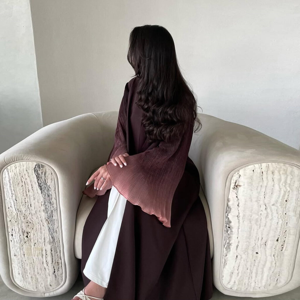 Woman sitting in armchair, long dark hair.