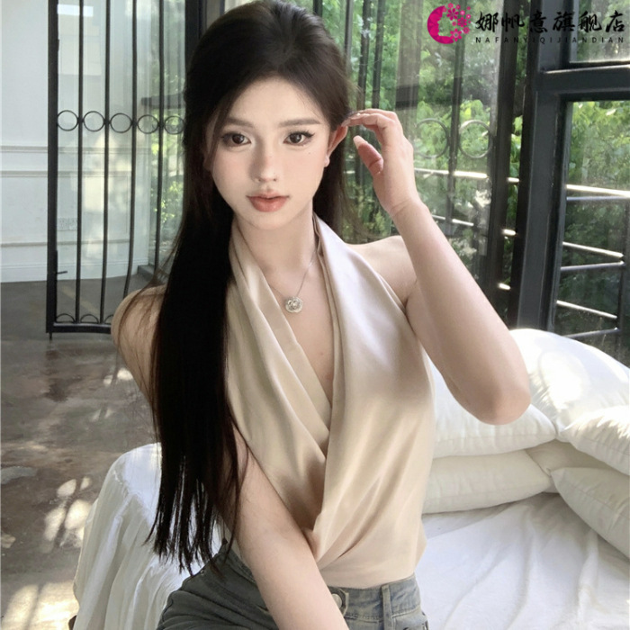 Woman sitting indoors, wearing beige top.