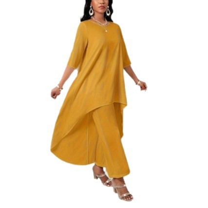 Woman wearing yellow asymmetrical dress and pants.