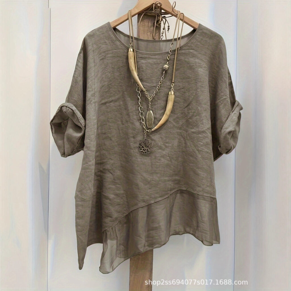 Gray blouse with layered necklace display.
