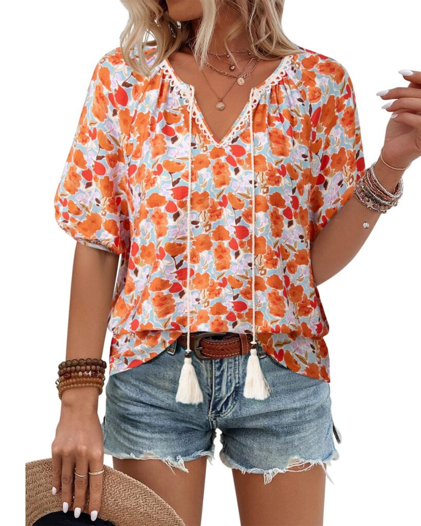 Woman in floral blouse and denim shorts.