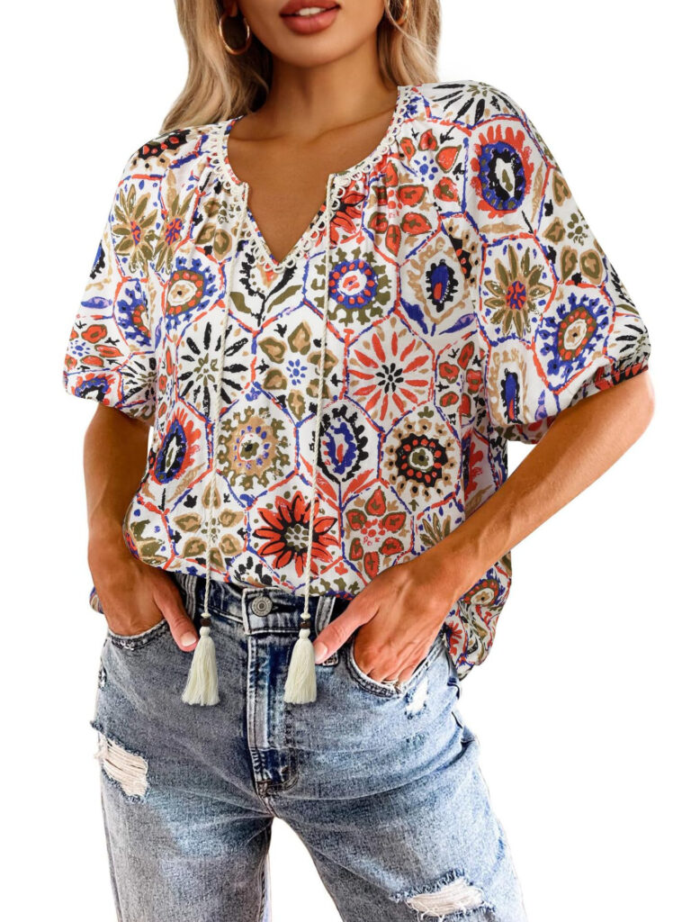 Woman wearing patterned blouse and ripped jeans.