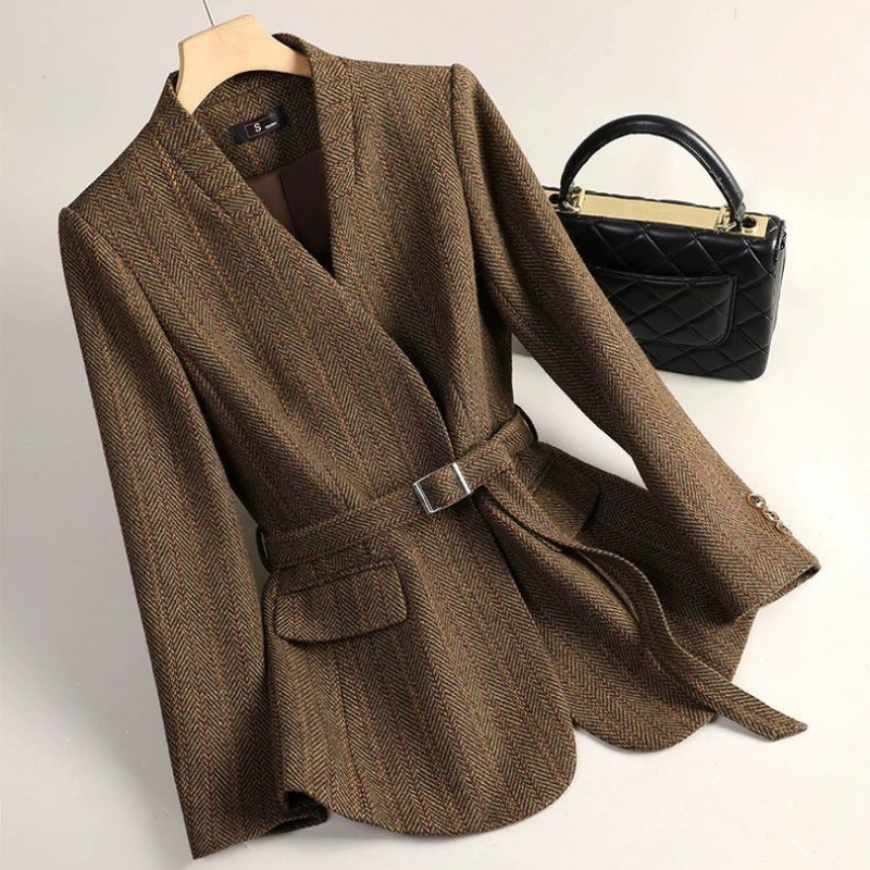 Brown blazer with belt and black handbag.