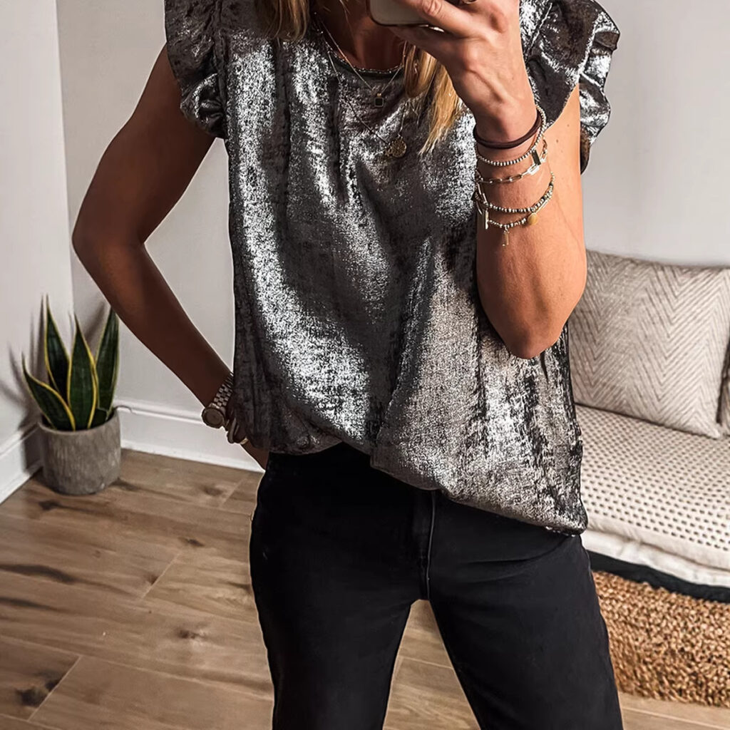 Person in shiny top taking a selfie.