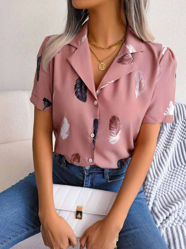 Woman in feather-patterned shirt with purse.