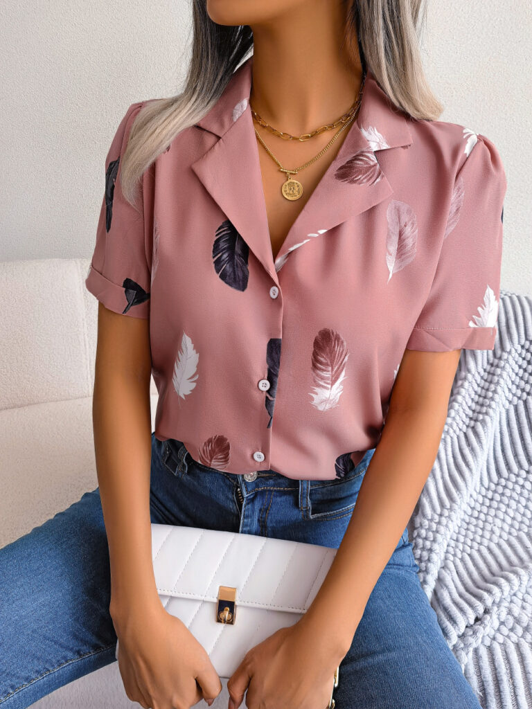 Woman in feather-print blouse holding clutch.