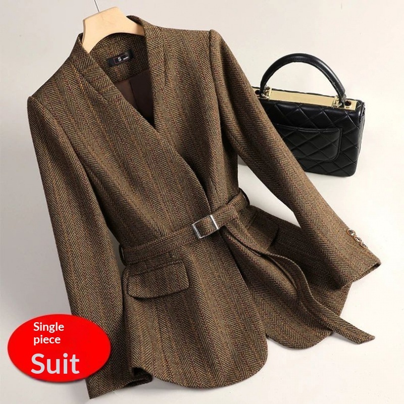 Brown suit jacket with black handbag.