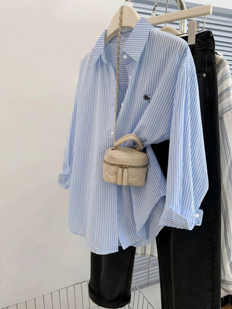 Striped shirt with small beige bag hanging.