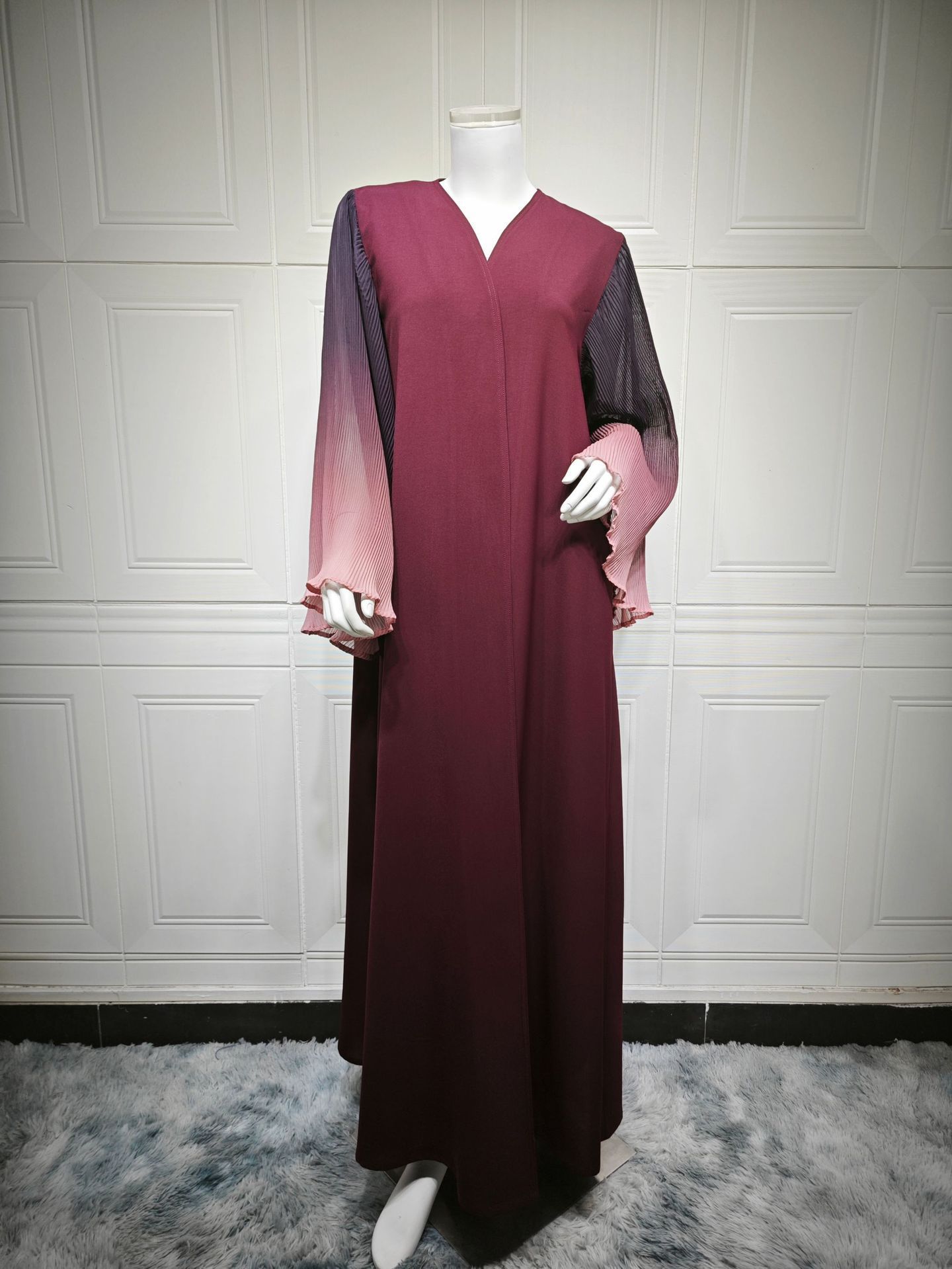 Maroon dress with gradient sleeves on mannequin.