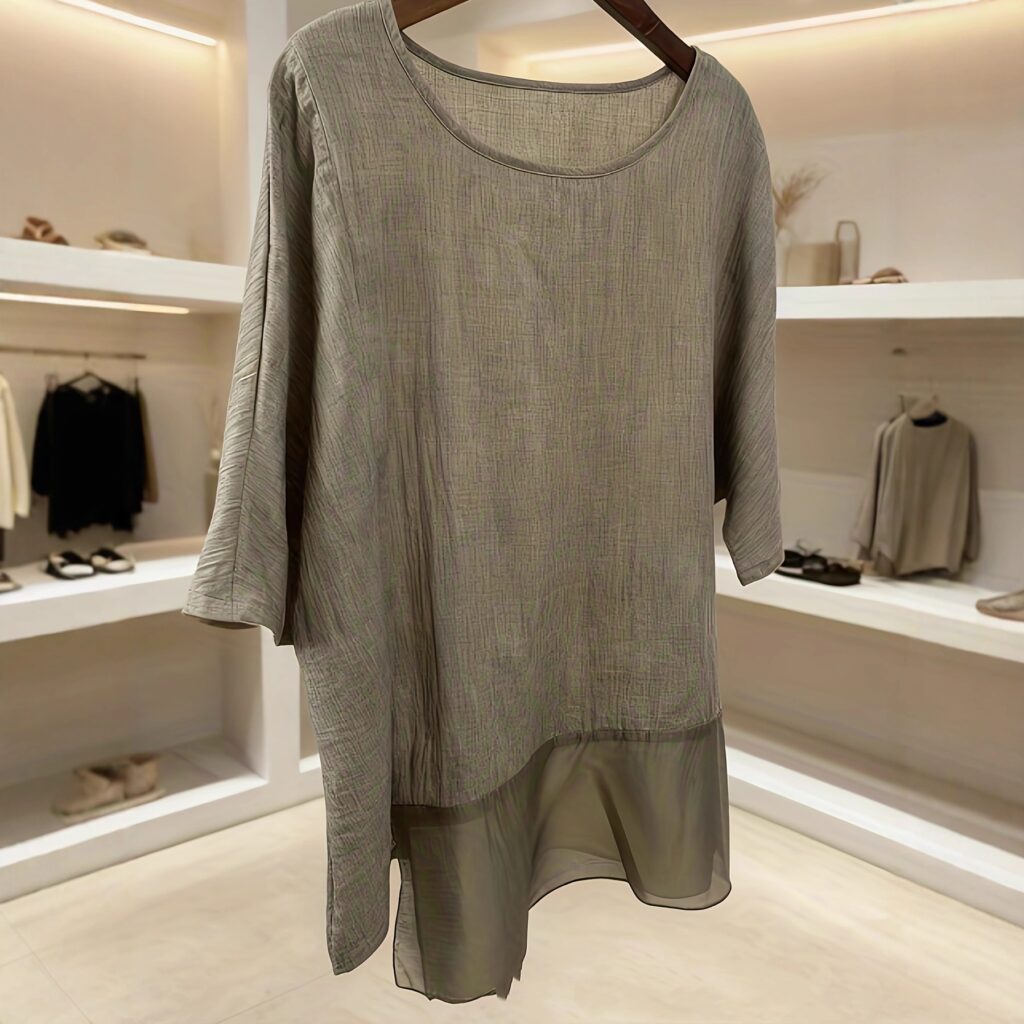 Gray tunic displayed in a modern store.