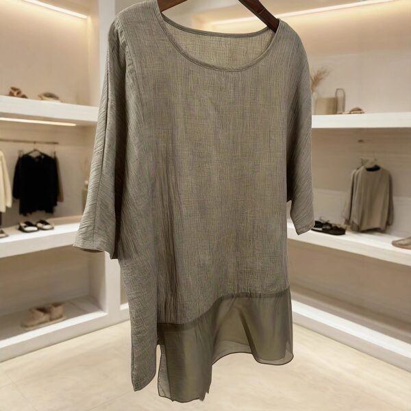 Gray tunic displayed in a modern store.