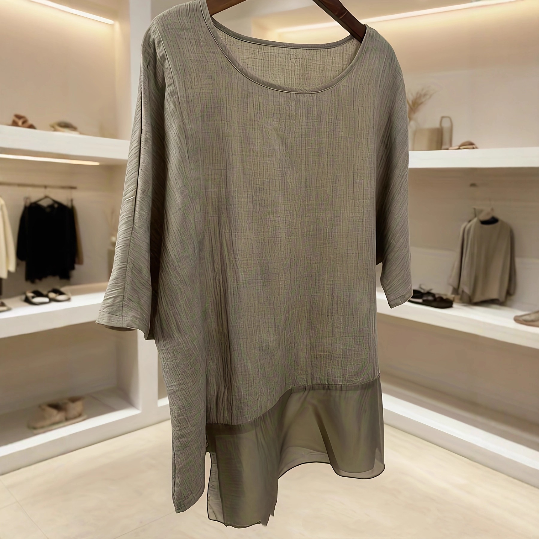 Gray tunic displayed in a modern store.