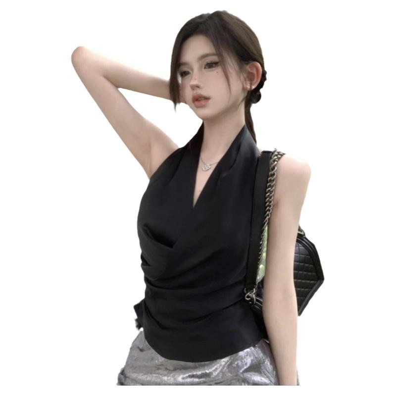 Woman in black top, silver skirt posing.