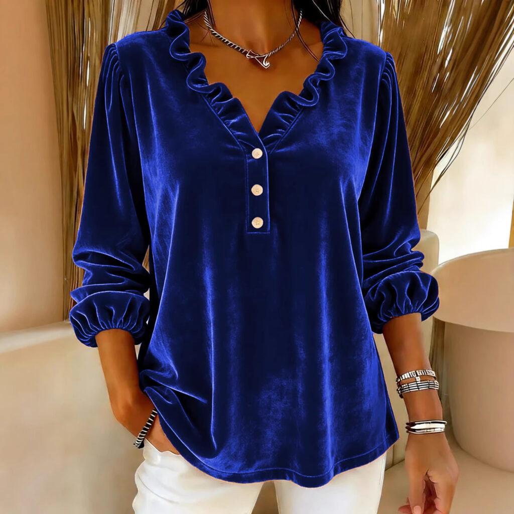 Woman in blue velvet blouse, indoors.