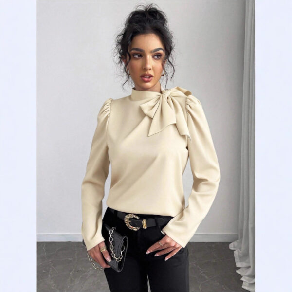 Woman in beige blouse and black pants.
