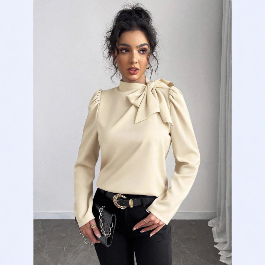 Woman in beige blouse and black pants.