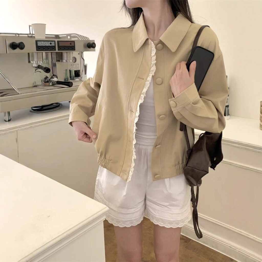 Woman in café holding phone and bag.