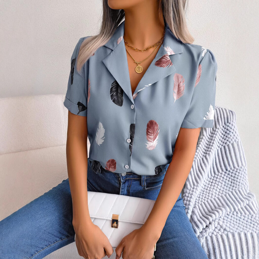 Woman in feather-patterned shirt holding clutch.