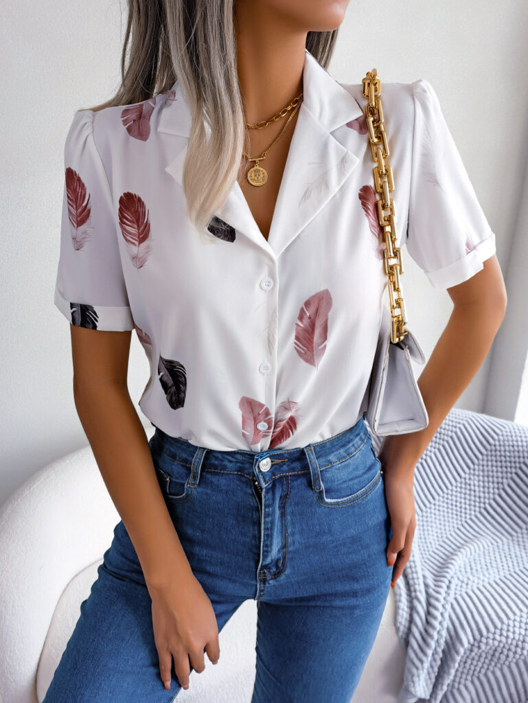Woman wearing feather-patterned blouse and jeans.
