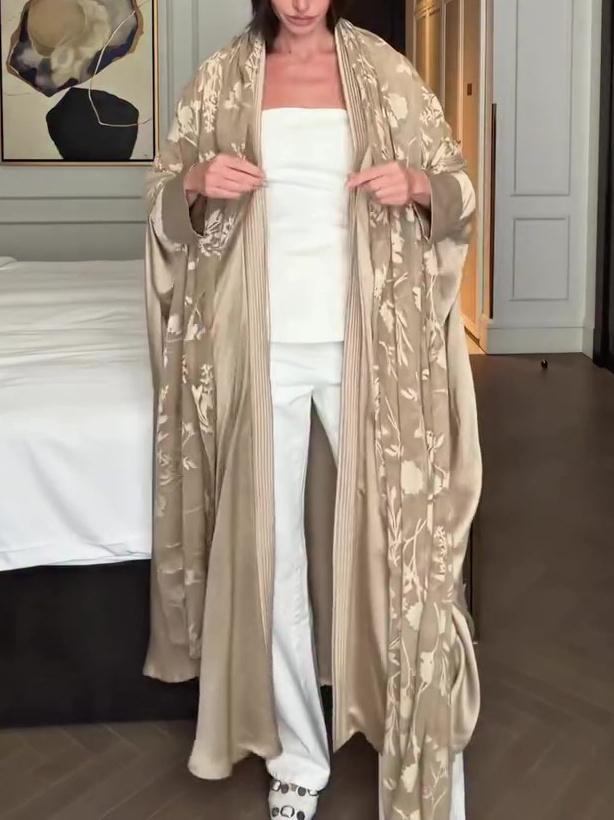 Woman wearing elegant floral robe at home.