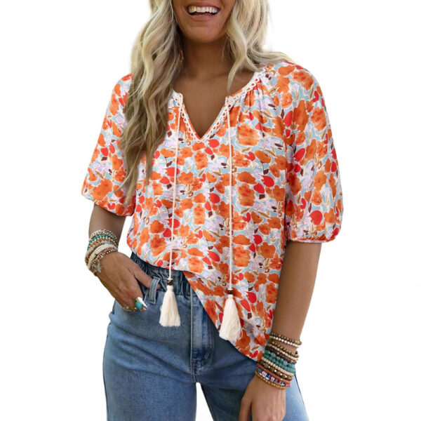Woman in floral blouse and jeans smiling.