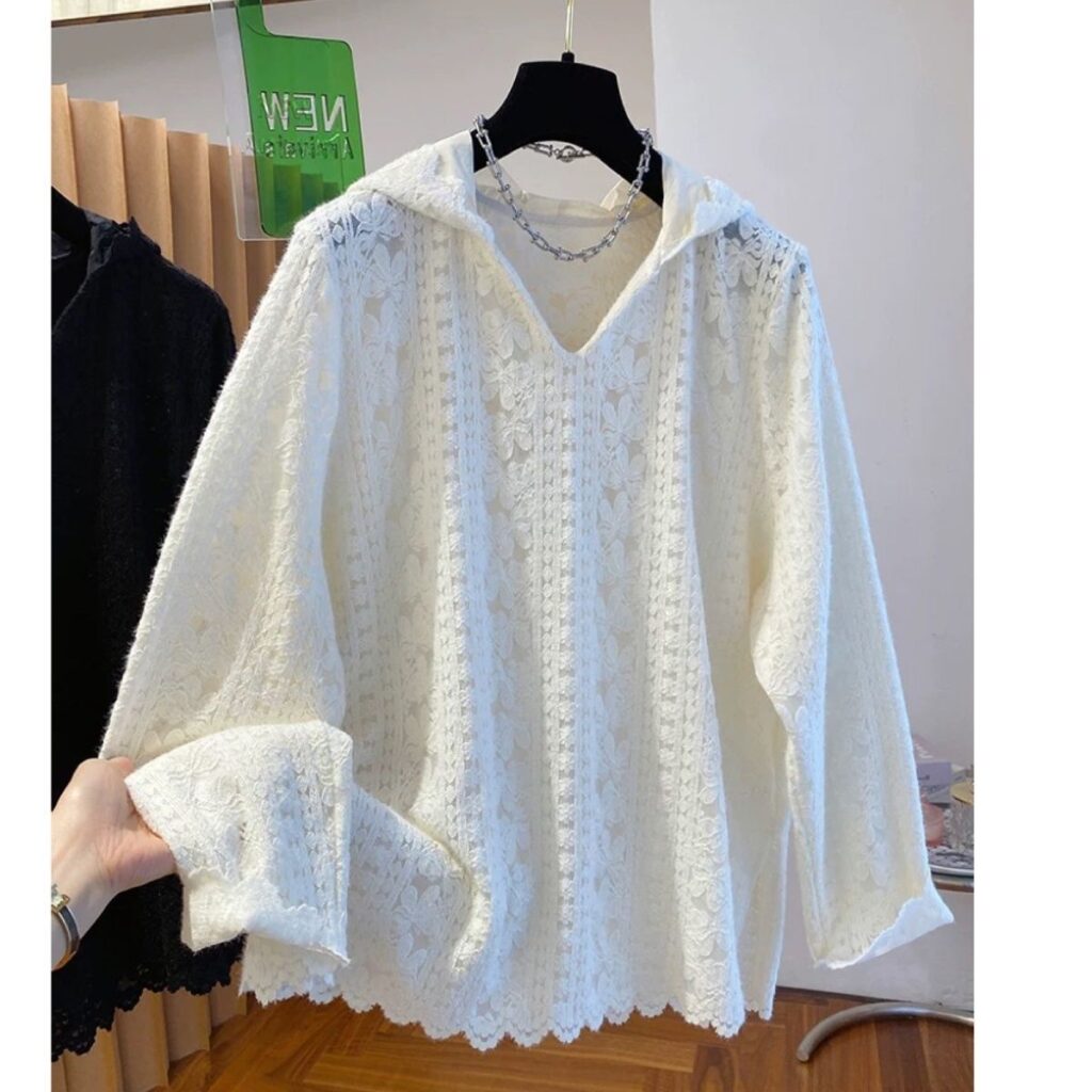 White lacy sweater on a hanger.