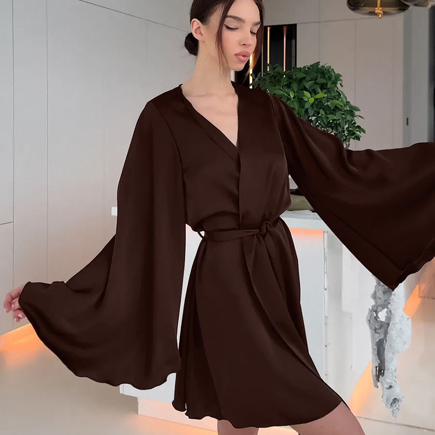 Woman in elegant brown dress posing indoors.