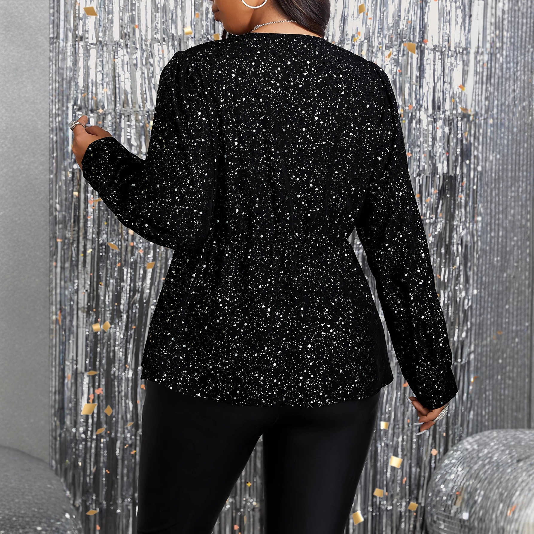 Woman in black sequin outfit, festive backdrop.