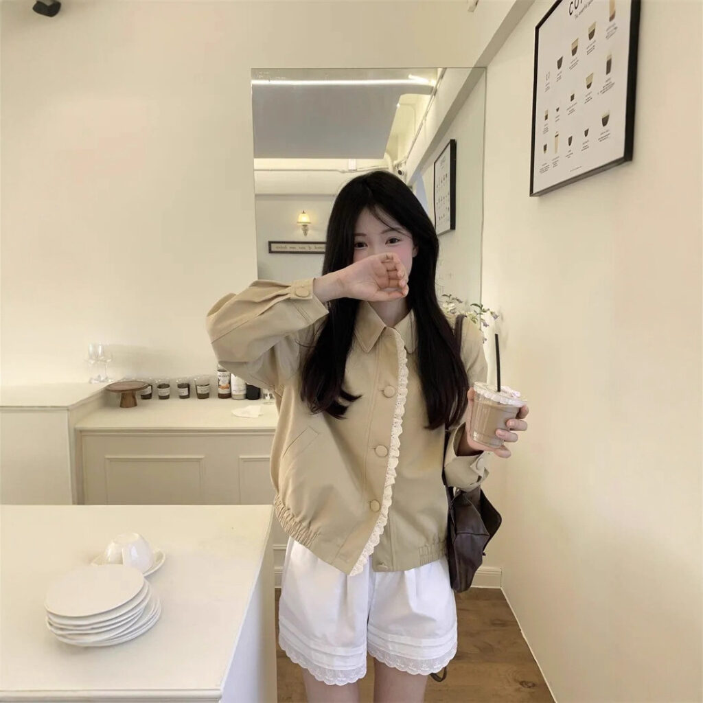 Woman holding drink in cozy cafe setting.