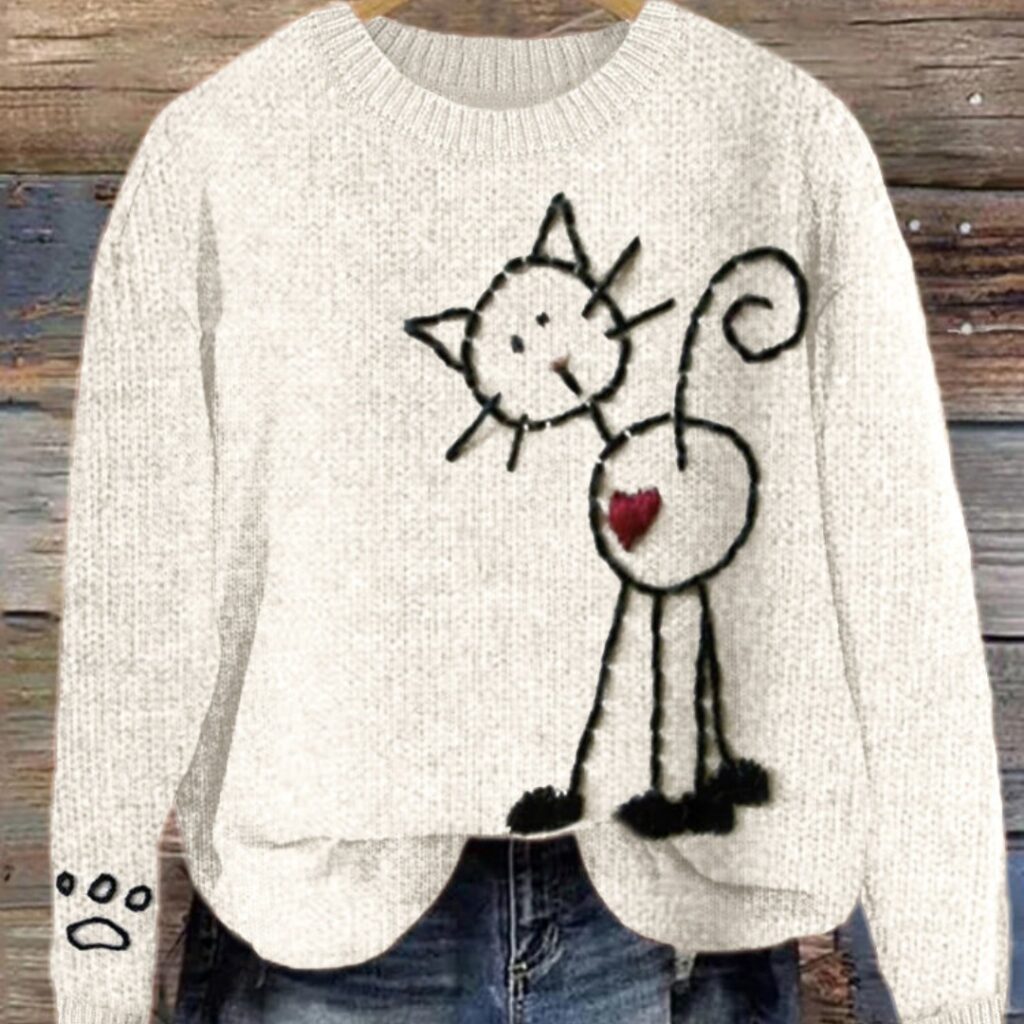 Gray sweater with whimsical cat illustration.