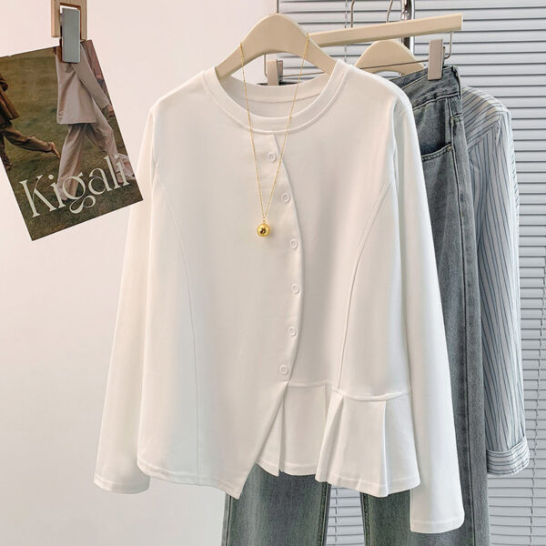 White blouse hanging with jeans and poster.