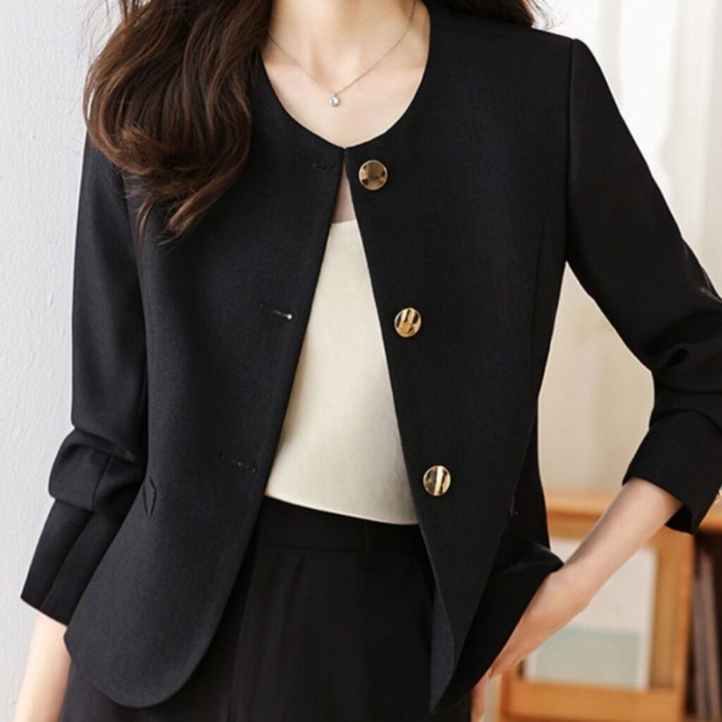 Woman in black blazer and white top.
